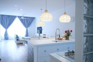 a kitchen with two pendant lights and a living room at Tung Kidcove Centrum Cameron in Brinchang