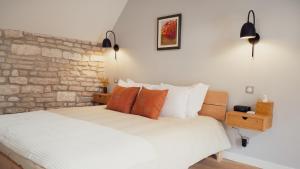 a bedroom with a white bed and a brick wall at Maisons Vaudésir - Rose, Chablis in Chablis