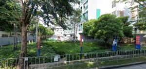 a park with trees and a fence in a city at Cozy apartment near Don Mueang airport in Lak Si