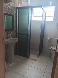 a bathroom with a shower and a toilet and a sink at Cantinho da Quinta 2 Quartos in Barra Velha