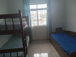 a bedroom with two bunk beds and a window at Cantinho da Quinta 2 Quartos in Barra Velha