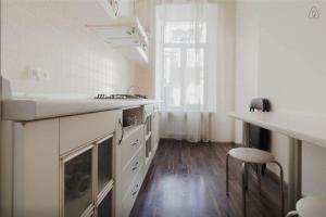 a large white kitchen with a sink and a stool at Apartment Julia 3 in Odesa