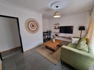 a living room with a couch and a television at Sandalwood Property in Lusaka