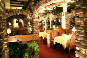 a restaurant with two tables and a brick wall at Hotel Restaurant Cristal in Wintzenheim