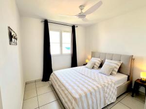a bedroom with a bed and a window at Le Blue Ocean - vue mer - parking - clim - wifi in Saint-Gilles-les-Bains