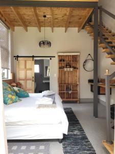 a bedroom with a white bed and wooden ceilings at Le Chateau Guest House and Conference Centre in Kempton Park