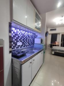 eine Küche mit einem Waschbecken und einer blauen Arbeitsplatte in der Unterkunft Pakuwon Mall Orchard Tanglin Anderson Tower WIFI Netflix by AquHome in Surabaya