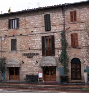 un gran edificio de ladrillo con un cartel. en Camere Santucci, en Asís