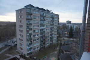 a tall apartment building is seen from a window at Apartament Erfolg 3 in Daugavpils