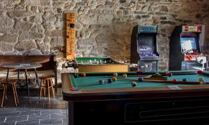 a game room with a pool table and arcade machines at Casa do Comediante in Cerdeira