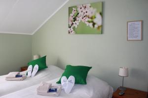 a bedroom with two beds with green and white pillows at Rene's B&B in Kerkrade