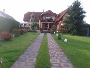 a house with a brick walkway in front of a yard at Alba Regia Pansion Egri in Jahodná