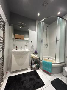 a bathroom with a shower and a sink and a tub at The Stag Ultracentral OldTown Apartment in Braşov +21 photos