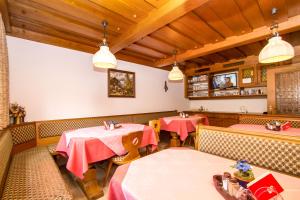 ein Restaurant mit 2 Tischen, Stühlen und Lampen in der Unterkunft Haus Helga in Unken