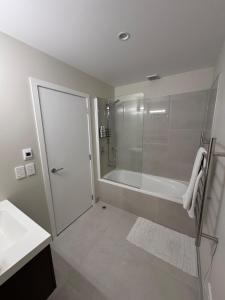 une salle de bain blanche avec une douche et une baignoire dans l'établissement Queenstown Retreat, à Queenstown