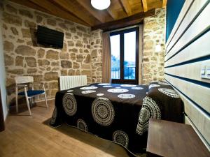 a bedroom with a bed and a stone wall at La Casa de Beli in Tardajos
