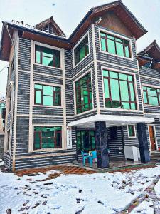 una casa con una sedia blu davanti di The Light House a Srinagar