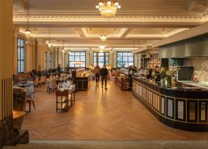 a large room with people walking through a restaurant at Hotel Mürren Palace in Mürren