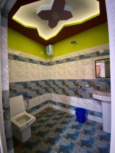 La salle de bains est pourvue de toilettes et d'un lavabo avec une croix au plafond. dans l'établissement Kanchenjunga View Mansions By StayApart, à Lataguri