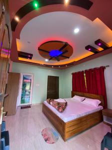 une chambre avec un grand lit avec un ventilateur de plafond dans l'établissement Kanchenjunga View Mansions By StayApart, à Lataguri