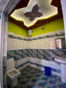 La salle de bains est pourvue de toilettes, d'un lavabo et d'une croix au plafond. dans l'établissement Kanchenjunga View Mansions By StayApart, à Lataguri