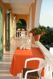 un tavolo arancione e sedie sul balcone di Angeliki a Vitalades