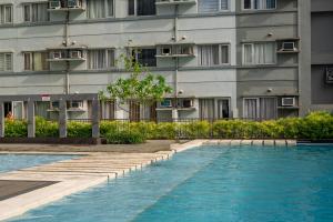 a hotel with a swimming pool in front of a building at Premium Apartments in Avida Towers l City Centre l Downtown l Close to Restaurants and Local Shops l by Bleuspace in Davao City