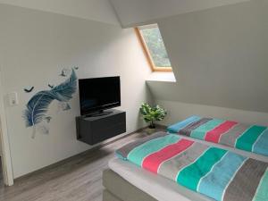 Un dormitorio con una cama y un televisor de pantalla plana. en Haus Seerose, en Lalendorf