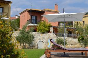 a white umbrella sitting on a bench in front of a house at Alkyon Villas in Syvota