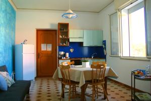 a kitchen with a table with chairs and a refrigerator at Giulietta b&b in Marsala