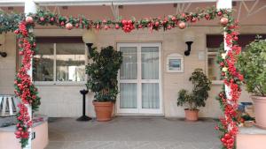 an arch with flowers and plants in front of a building at Hotel San Paolo in Varazze