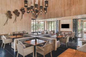 a restaurant with wooden walls and tables and chairs at Dusit Thani Krabi Beach Resort in Klong Muang Beach