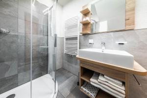 een badkamer met een wastafel en een douche bij Appartamenti Vilin in San Cassiano +10 foto's