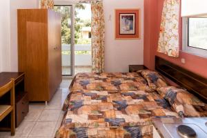 a bedroom with a bed and a desk and a window at Aphrodite Apartments in Kallithea Rhodes