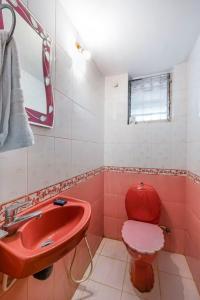 a bathroom with a red toilet and a sink at Casa De Fazenda - Farmhouse, Diwar Island in Divar +7 photos