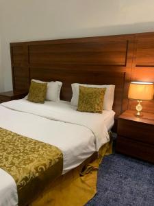 ein Hotelzimmer mit zwei Betten und einer Lampe in der Unterkunft شقق درة المزهر المخدومة in Riad