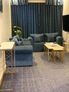 ein Wohnzimmer mit einer Couch und zwei Tischen in der Unterkunft شقق درة المزهر المخدومة in Riad