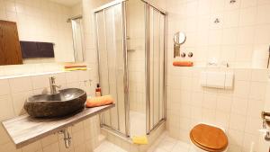 ein Bad mit einem Waschbecken und einer Dusche in der Unterkunft Hotel Nordic Spreewald in Lübbenau