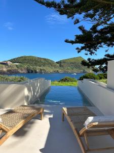a view of a lake from a house with benches at Silveira Bay Lounge Retreat in Angra do Heroísmo