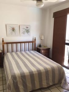 Un dormitorio con una cama con una manta a rayas. en Frente Para O Mar, en Río de Janeiro