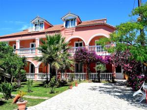 a large pink house with trees and flowers at Villasabella in Laganas