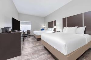 a hotel room with two beds and a desk at La Quinta by Wyndham Tyler - University Area in Tyler +35 photos