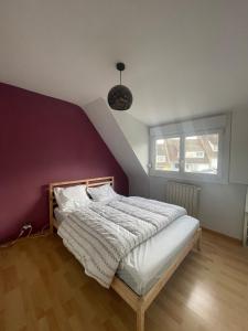 a bedroom with a bed with a purple wall at L Envie d Opale Maison familiale avec jardin a Wimereux in Wimereux