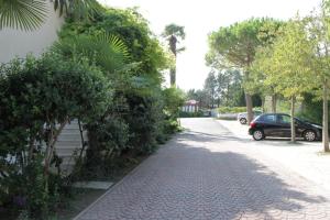 a street with trees and a car parked on the street at Hotel Ristorante Fortuna in Cavallino-Treporti