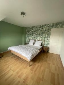 a bedroom with a bed with a green wall at L Envie d Opale Maison familiale avec jardin a Wimereux in Wimereux