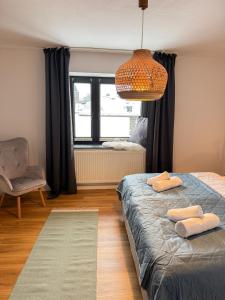 a bedroom with a bed and a chair and a window at Eifelstube - Cozy 130 qm apartment with big sun terrace in Monschau