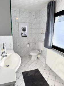 a white bathroom with a sink and a toilet at Eifelstube - Cozy 130 qm apartment with big sun terrace in Monschau +30 photos