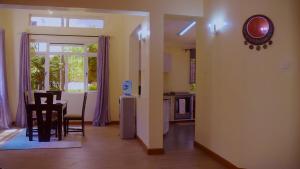 a kitchen and a dining room with a table and chairs at La Casa Savanna in Naivasha