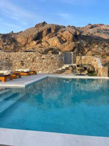una grande piscina con una montagna sullo sfondo di Apostolis Windmill a Psarou