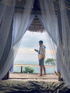 Ein Mann steht in einem Zimmer mit Fenster. in der Unterkunft กาแฟอาลูลูดอยล้าน in Mae Suai + 70 Fotos